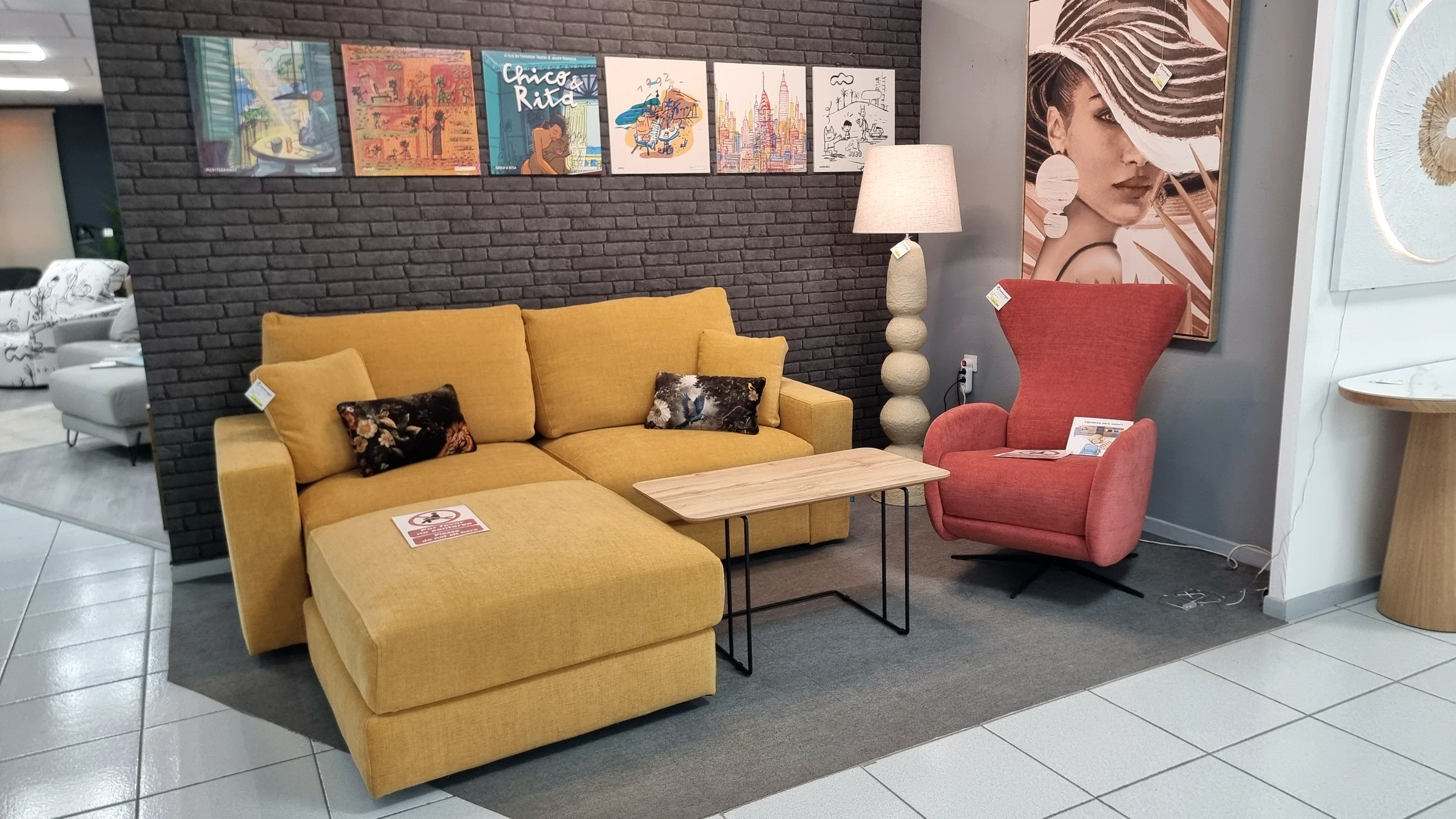 Ambiente con sofá chaise longue y sillón en la exposición de Centrogar