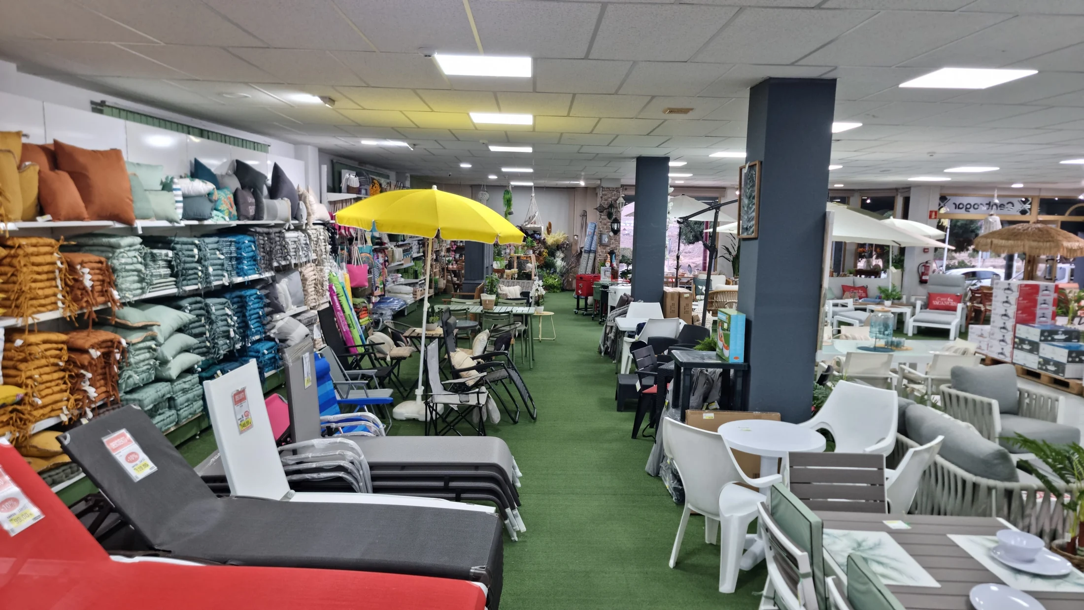 Surtido de cojines y colchonetas junto a muebles de jardín en Centrogar
