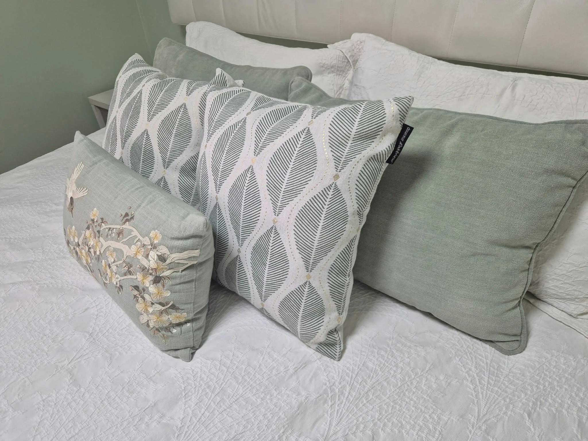 Detalle de cojines y ropa de cama coordinados en un dormitorio real con productos Centrogar